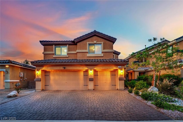 326 Caneflower Ct, North Las Vegas, NV 89031 - view of front of home with an attached garage, decorative driveway, stucco siding, and a tile roof