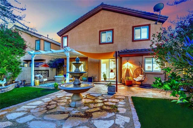 326 Caneflower Ct, North Las Vegas, NV 89031 - back of house at dusk with stucco siding, a patio area, a pergola, and a tile roof