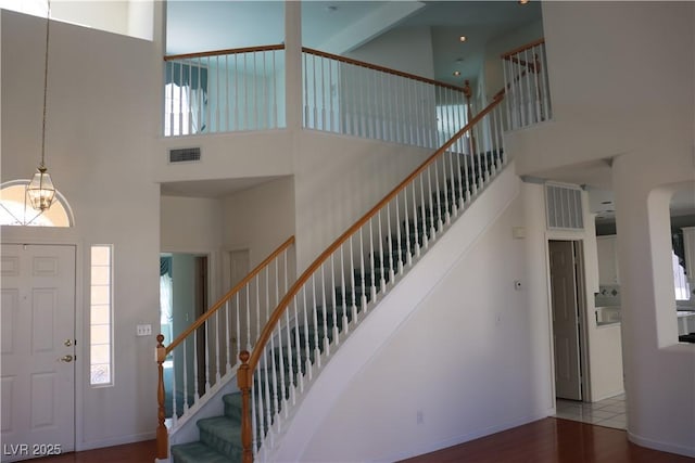 8982 Emerald Waters Ct, Las Vegas, NV 89147 - foyer featuring a towering ceiling, stairway, wood finished floors, and healthy amount of natural light