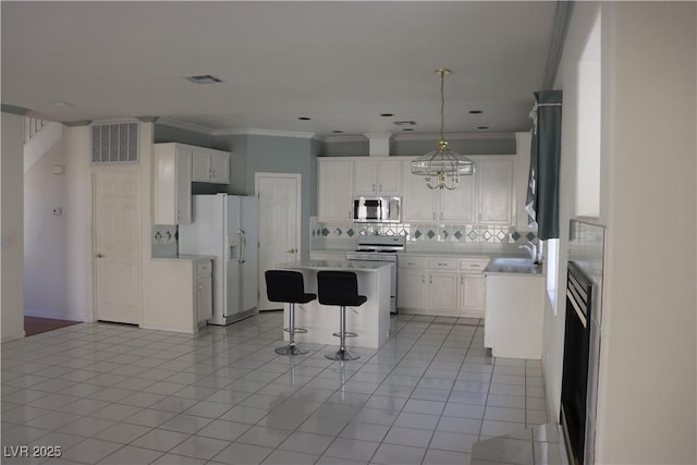 8982 Emerald Waters Ct, Las Vegas, NV 89147 - kitchen with white appliances, backsplash, a breakfast bar area, a center island, and white cabinetry