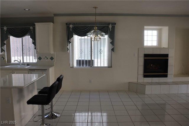 8982 Emerald Waters Ct, Las Vegas, NV 89147 - dining space featuring a chandelier, ornamental molding, a fireplace, and light tile patterned floors