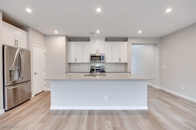 11922 Glide Reflection Ave, Las Vegas, NV 89138 - kitchen featuring stainless steel appliances, light countertops, light wood-style floors, decorative backsplash, and recessed lighting