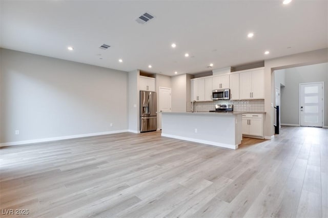 11922 Glide Reflection Ave, Las Vegas, NV 89138 - kitchen with stainless steel appliances, open floor plan, backsplash, white cabinets, and recessed lighting
