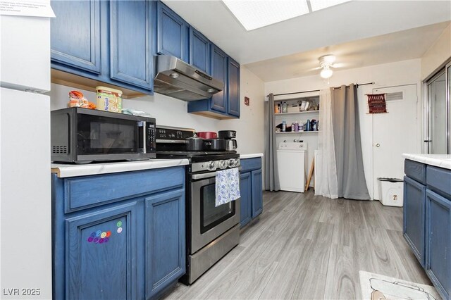 4232 Park Ct, Las Vegas, NV 89110 - kitchen featuring washer / clothes dryer, electric range, blue cabinetry, under cabinet range hood, and freestanding refrigerator