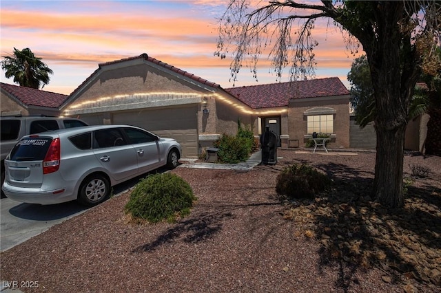 2716 Orchid Moon Ct, North Las Vegas, NV 89031 - view of front of home featuring an attached garage, concrete driveway, a tile roof, and stucco siding