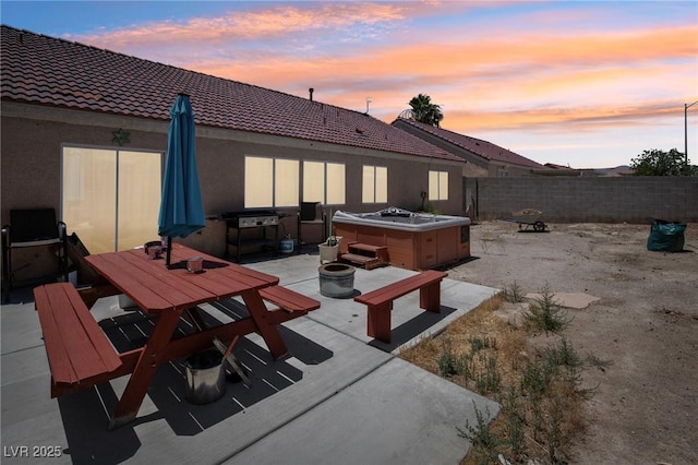 2716 Orchid Moon Ct, North Las Vegas, NV 89031 - patio terrace at dusk featuring a hot tub, a patio area, a fire pit, and a fenced backyard
