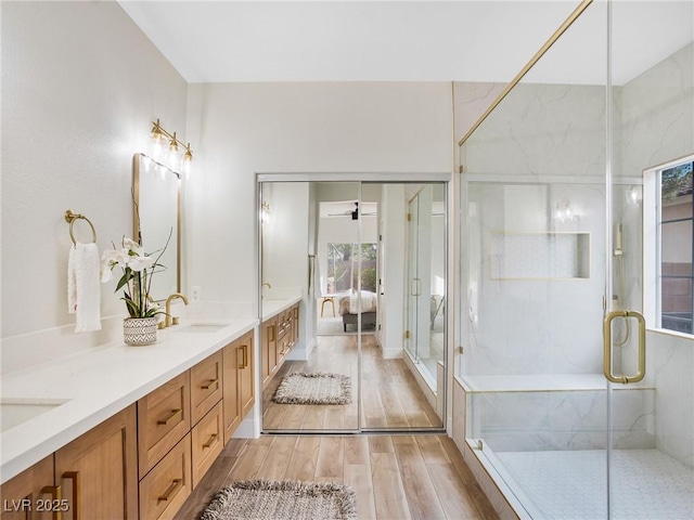 4314 Livorno Ave, Las Vegas, NV 89141 - bathroom featuring double vanity, wood finished floors, a marble finish shower, ceiling fan, and connected bathroom