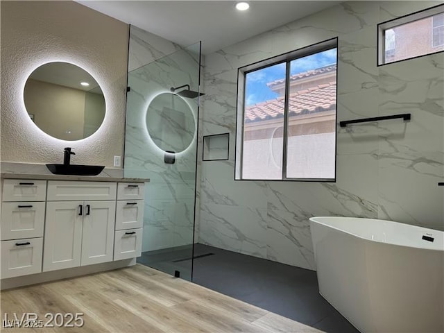9272 W Viking Rd, Las Vegas, NV 89147 - bathroom featuring vanity, a marble finish shower, a freestanding tub, healthy amount of natural light, and a textured wall