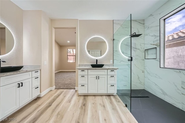 9272 W Viking Rd, Las Vegas, NV 89147 - full bathroom featuring a marble finish shower, two vanities, and wood finished floors