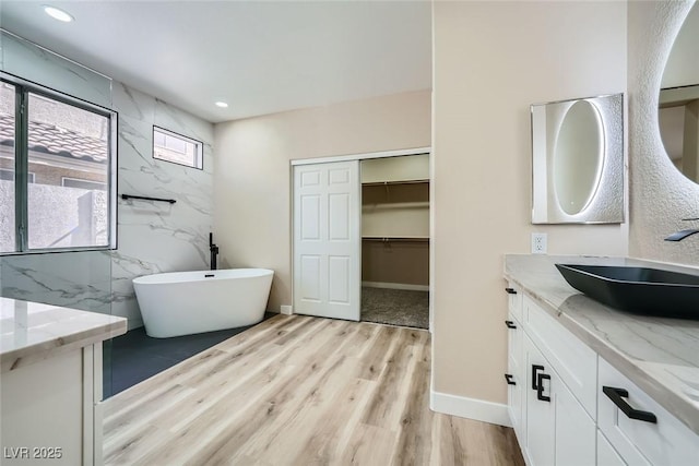 9272 W Viking Rd, Las Vegas, NV 89147 - bathroom featuring vanity, a freestanding bath, wood finished floors, recessed lighting, and a walk in closet