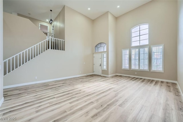 9272 W Viking Rd, Las Vegas, NV 89147 - unfurnished living room with a high ceiling, wood finished floors, and recessed lighting