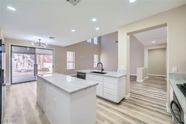 9272 W Viking Rd, Las Vegas, NV 89147 - kitchen featuring a center island, white cabinets, light wood-style flooring, light stone countertops, and recessed lighting