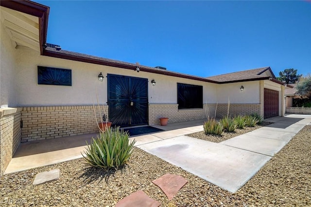 3917 Leon Ave, Las Vegas, NV 89130 - entrance to property with brick siding, a garage, and stucco siding