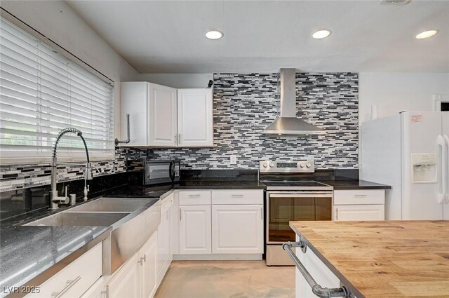 3917 Leon Ave, Las Vegas, NV 89130 - kitchen featuring stainless steel range with electric stovetop, wall chimney exhaust hood, white fridge with ice dispenser, butcher block counters, and white cabinets