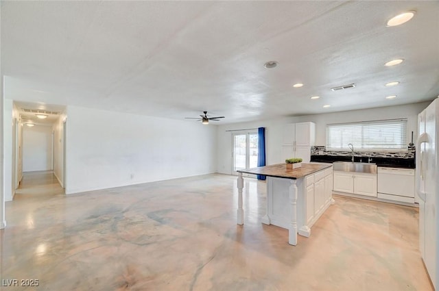 3917 Leon Ave, Las Vegas, NV 89130 - kitchen featuring dishwasher, white cabinetry, a kitchen island, a ceiling fan, and a kitchen breakfast bar