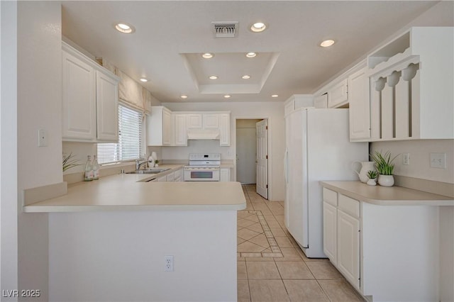 2808 Crown Ridge Dr, Las Vegas, NV 89134 - kitchen featuring stove, light tile patterned floors, freestanding refrigerator, a raised ceiling, and a peninsula