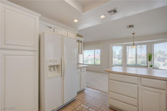 2808 Crown Ridge Dr, Las Vegas, NV 89134 - kitchen with white fridge with ice dispenser, light carpet, light tile patterned floors, recessed lighting, and white cabinetry