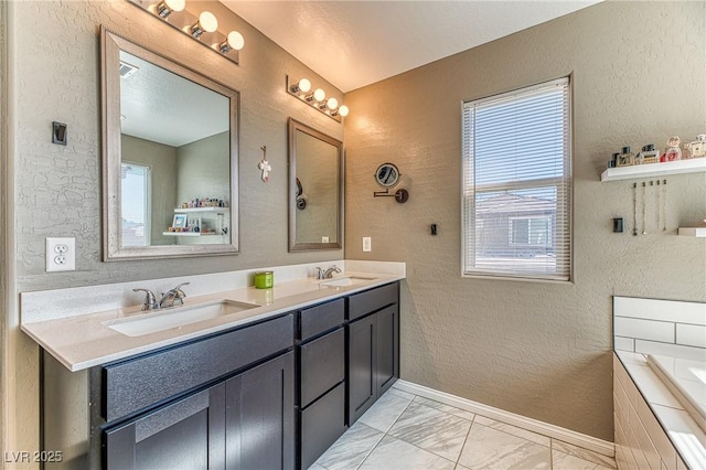 10042 Bismuth St, Las Vegas, NV 89183 - full bathroom with a textured wall, marble finish floors, double vanity, and tiled bath