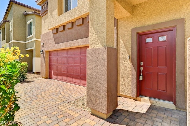 934 Twincrest Ave, North Las Vegas, NV 89032 - view of exterior entry with stucco siding, a garage, and decorative driveway