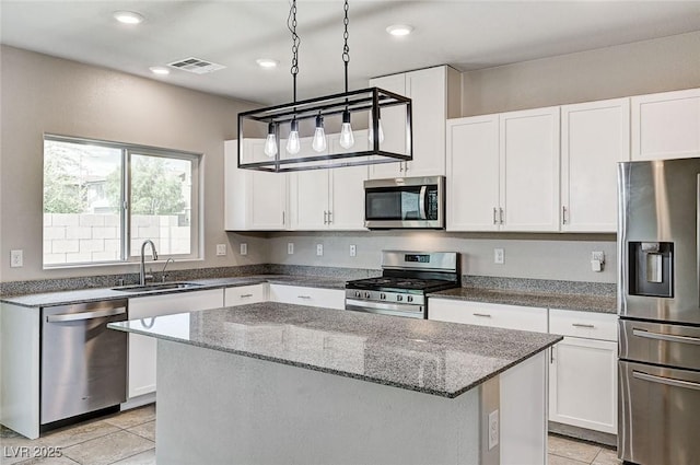 934 Twincrest Ave, North Las Vegas, NV 89032 - kitchen featuring stainless steel appliances, light tile patterned flooring, dark stone countertops, a kitchen island, and white cabinetry