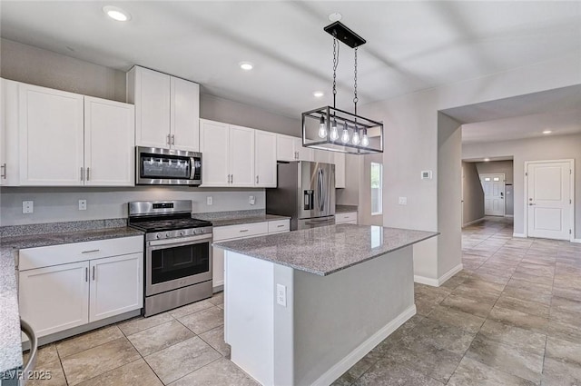 934 Twincrest Ave, North Las Vegas, NV 89032 - kitchen with appliances with stainless steel finishes, a kitchen island, white cabinetry, light stone counters, and hanging light fixtures