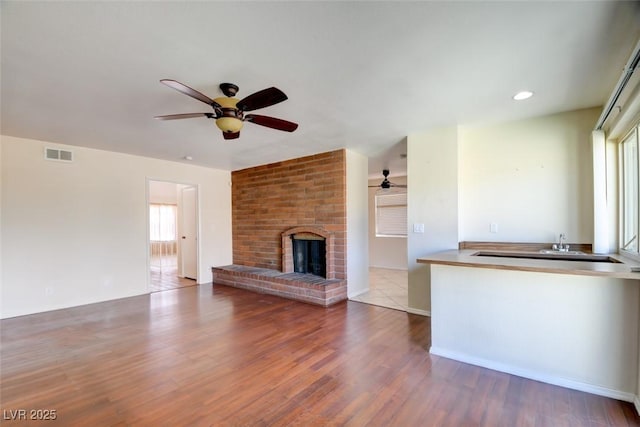 6822 Garden Grove Ave, Las Vegas, NV 89103 - unfurnished living room with ceiling fan, wood finished floors, and a fireplace