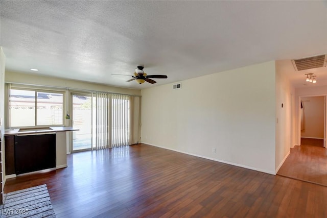 6822 Garden Grove Ave, Las Vegas, NV 89103 - unfurnished living room featuring dark wood-type flooring, ceiling fan, and a textured ceiling