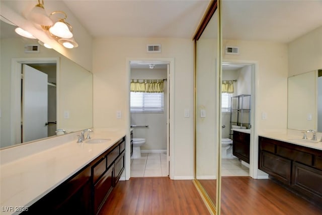 6822 Garden Grove Ave, Las Vegas, NV 89103 - bathroom featuring two vanities and wood finished floors