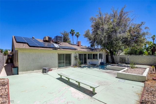 6822 Garden Grove Ave, Las Vegas, NV 89103 - rear view of property featuring a patio area, stucco siding, solar panels, and a fenced backyard