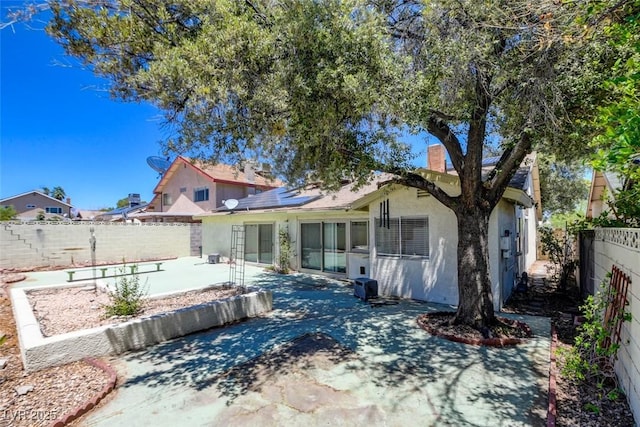 6822 Garden Grove Ave, Las Vegas, NV 89103 - back of house with stucco siding, a patio, a fenced backyard, and a chimney