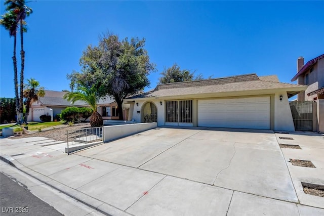 6822 Garden Grove Ave, Las Vegas, NV 89103 - ranch-style home featuring a garage, driveway, stucco siding, and a gate