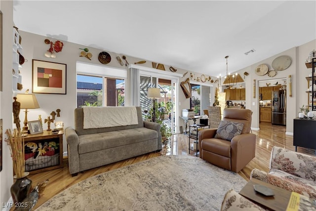 9237 Quail Ridge Dr, Las Vegas, NV 89134 - living room featuring plenty of natural light, light wood-style flooring, and a chandelier