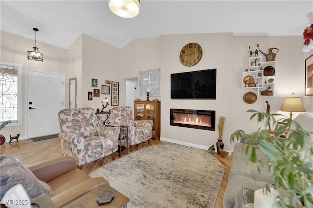 9237 Quail Ridge Dr, Las Vegas, NV 89134 - living room featuring wood finished floors, a glass covered fireplace, and high vaulted ceiling