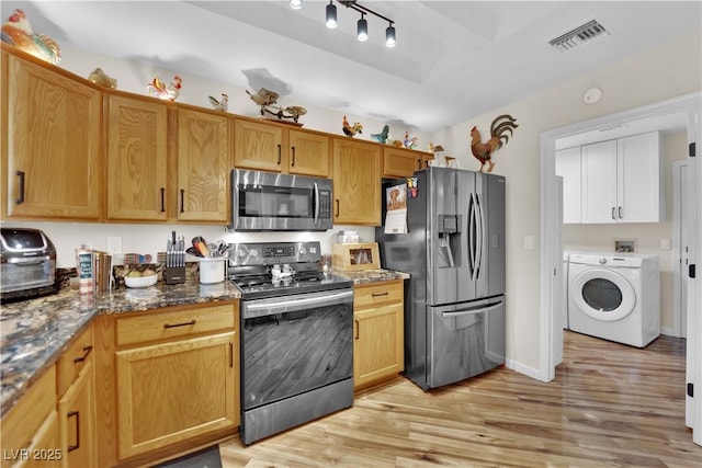 9237 Quail Ridge Dr, Las Vegas, NV 89134 - kitchen with stainless steel appliances, washer / clothes dryer, light wood-style flooring, and dark stone countertops