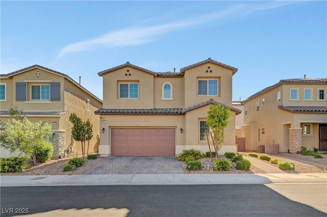 4641 Therapeutic St, North Las Vegas, NV 89031 - mediterranean / spanish-style home with stucco siding, an attached garage, a tiled roof, and decorative driveway