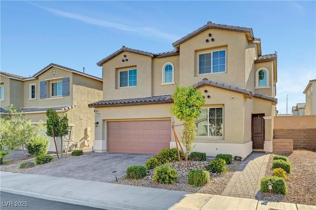 4641 Therapeutic St, North Las Vegas, NV 89031 - mediterranean / spanish-style home with a tile roof, a garage, stucco siding, and driveway