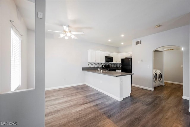 6006 Vegas Dr, Las Vegas, NV 89108 - kitchen with washer and dryer, black appliances, arched walkways, ceiling fan, and a peninsula