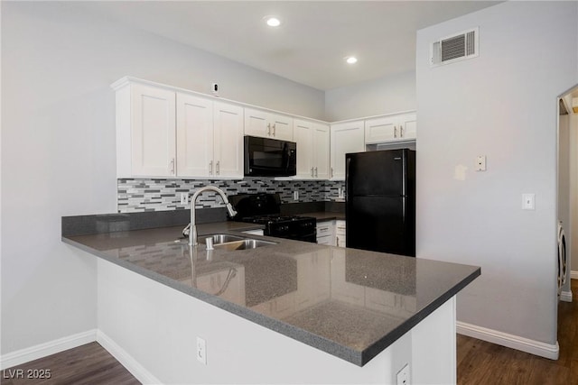 6006 Vegas Dr, Las Vegas, NV 89108 - kitchen with black appliances, decorative backsplash, a peninsula, white cabinets, and dark wood-style floors