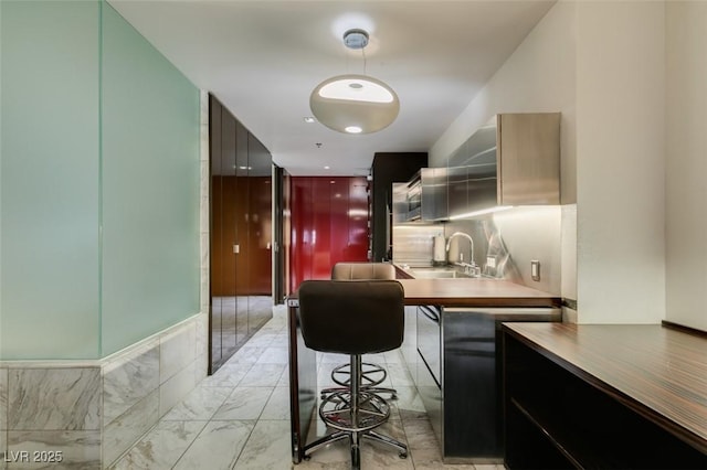 4381 Flamingo Rd Unit 2010, Las Vegas, NV 89103 - kitchen with modern cabinets, light marble finish floors, and decorative light fixtures