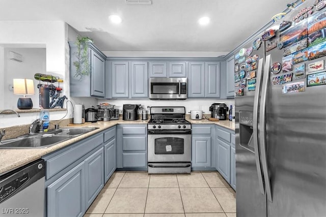 6068 Conroe Ct, Las Vegas, NV 89118 - kitchen with stainless steel appliances, light countertops, light tile patterned floors, recessed lighting, and gray cabinetry