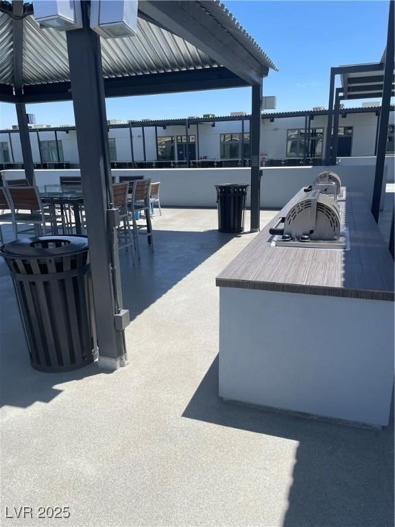 8925 W Flamingo Rd Unit 105, Las Vegas, NV 89147 - view of patio featuring exterior bar, an outdoor kitchen, and outdoor dining area