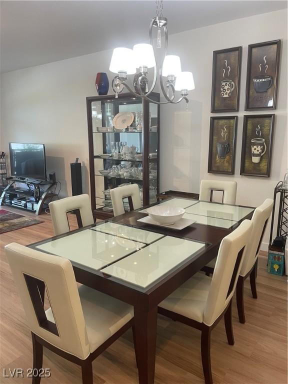 8925 W Flamingo Rd Unit 105, Las Vegas, NV 89147 - dining area featuring a chandelier and wood finished floors