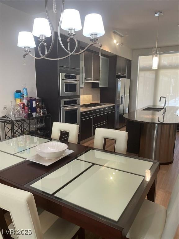 8925 W Flamingo Rd Unit 105, Las Vegas, NV 89147 - dining space featuring a chandelier and wood finished floors