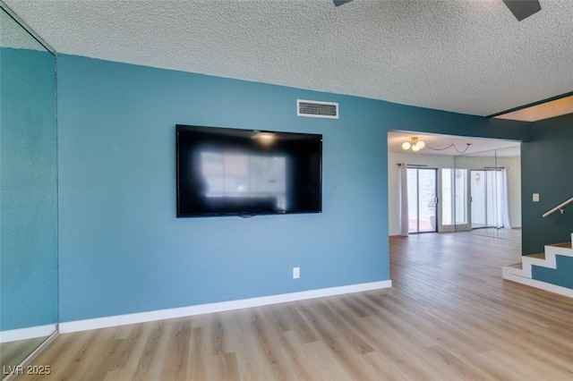 3785 Decade St, Las Vegas, NV 89121 - unfurnished living room with wood finished floors, stairs, and a textured ceiling