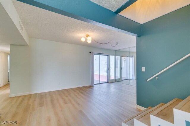 3785 Decade St, Las Vegas, NV 89121 - spare room with light wood finished floors, a textured ceiling, and stairway
