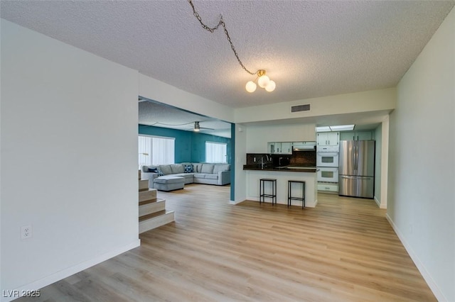 3785 Decade St, Las Vegas, NV 89121 - living room featuring a textured ceiling, light wood-style floors, and ceiling fan