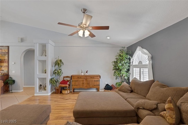 9015 S Tenaya Way, Las Vegas, NV 89113 - living room featuring arched walkways, vaulted ceiling, ceiling fan, and light wood-style flooring