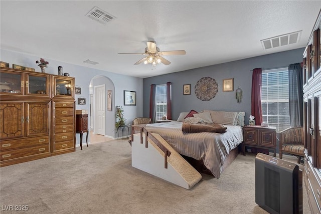 9015 S Tenaya Way, Las Vegas, NV 89113 - bedroom featuring arched walkways, light carpet, and a ceiling fan