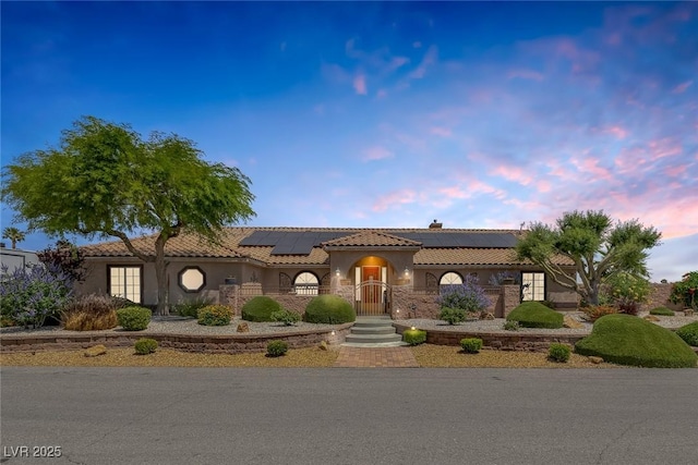 9015 S Tenaya Way, Las Vegas, NV 89113 - mediterranean / spanish house with roof mounted solar panels, stucco siding, a tile roof, and a chimney