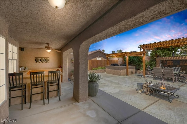 9015 S Tenaya Way, Las Vegas, NV 89113 - patio terrace at dusk featuring area for grilling, a patio, a pergola, outdoor dining space, and ceiling fan